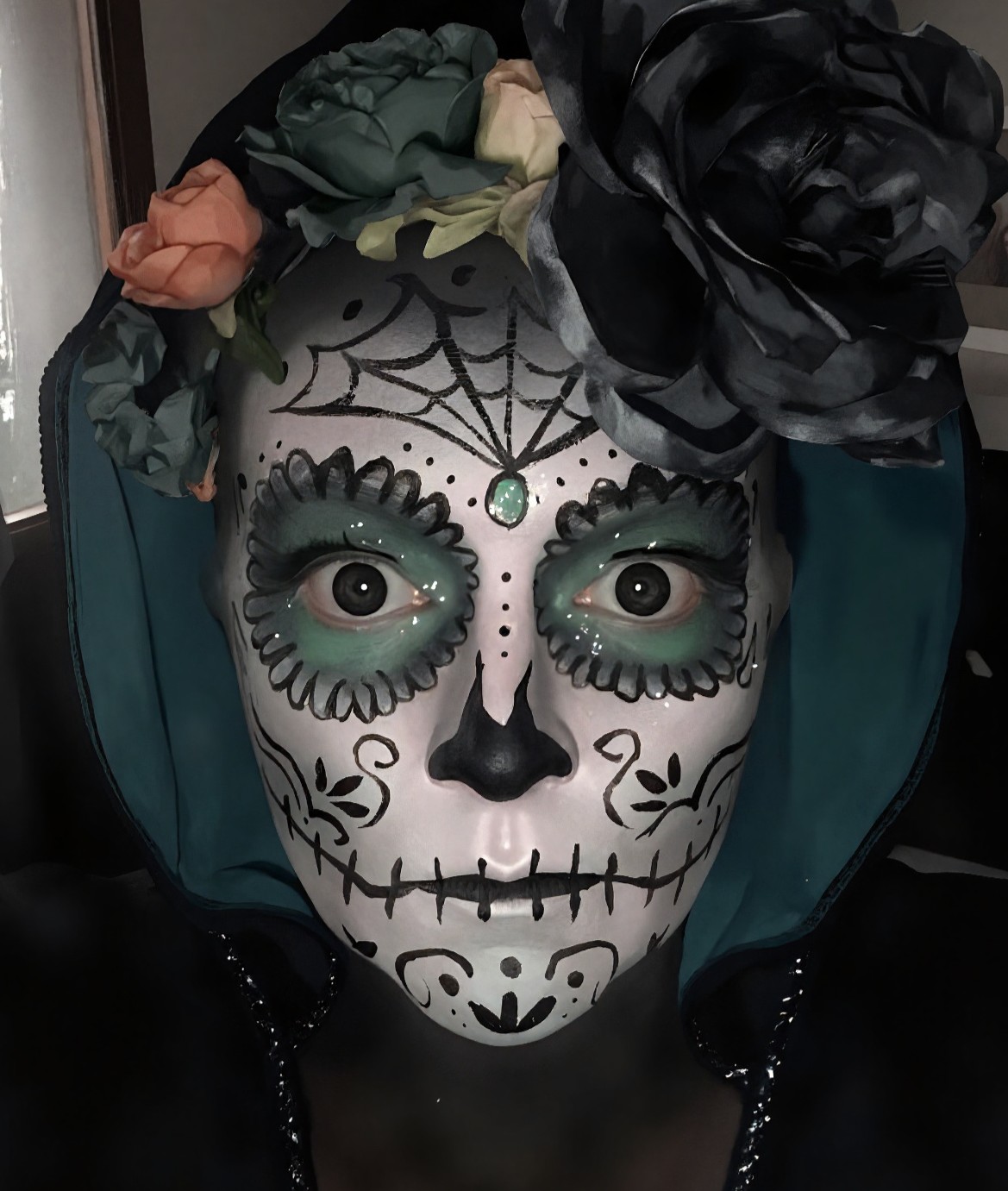Day of the Dead sugar skull face painting with cobweb and floral detail